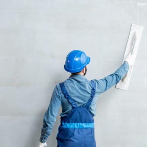 Worker applying Ideal Drymix wall plaster for smooth interior finish