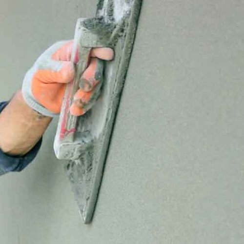Applying Ideal Drymix plaster with trowel for smooth wall finish